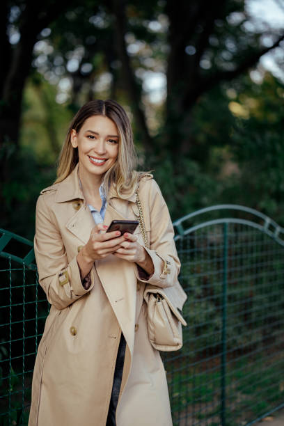 istock Young lady using her mobile device in a city street while walking. 1969411135