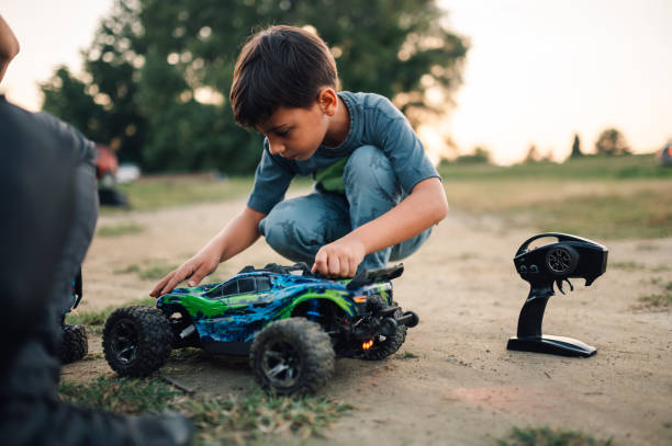 istock Boy getting his remote toy car ready before play outdoors. 1969411684