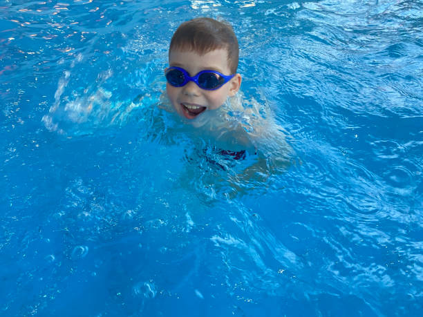 menino alegre nadando na piscina - mobilestock freedom enjoyment blue - fotografias e filmes do acervo