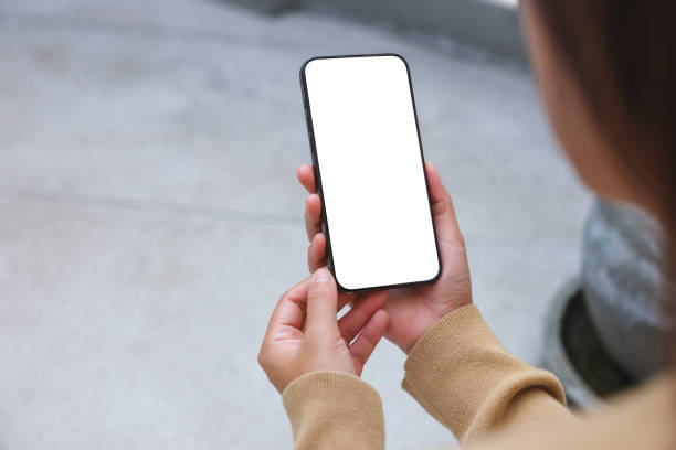 istock Mockup image of a woman holding mobile phone with blank desktop white screen 1969438012