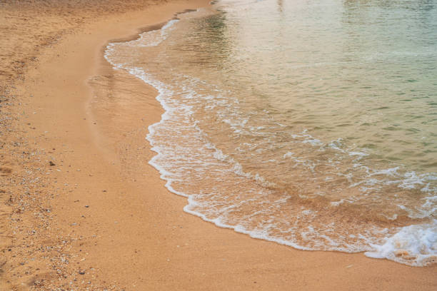Beach with beautiful brown sand and clear blue water.
