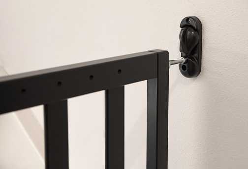 Baby gate safety door, black fence for safety children on stairs, selective focus