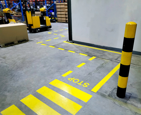 Walkway,footpath,Industrial building corridor painted yellow between parallel yellow lines on abstract cement background. Sidewalk Negotiation Safety Concept