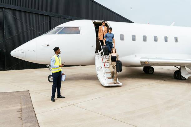 istock Passengers boarding in private luxury jet near hangar, pilot welcomes the young successful passengers 1969469410
