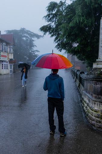 Portrait of man in wet clothes with eyes closed enjoying heavy rain in nature. Themes of life water, weather and environment.