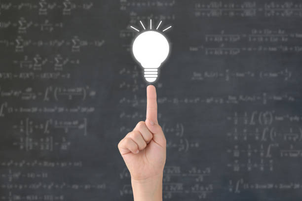 難しい数学の質問の背景を持つ子供の手と電球 - 電球 ストックフォトと画像