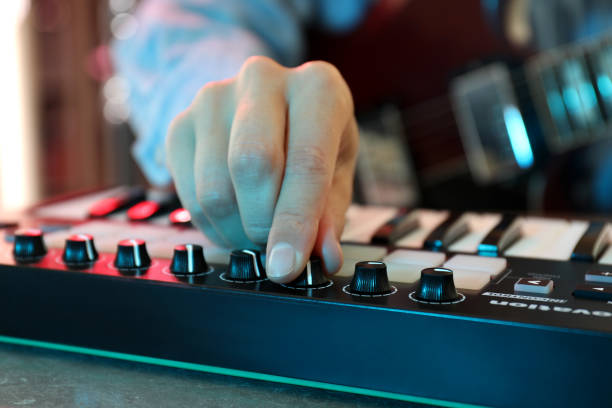 istock Musician playing on electric guitar and midi keyboard, close up 1969488005