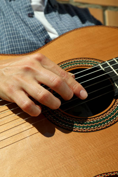 istock Woman in shirt playing on classical guitar 1969495990