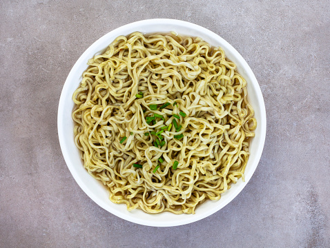 Flat lay of spinach and kale ramen noodles on mottled grey surface with copy space