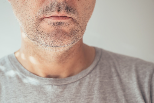 Male chin and jawline, closeup of unshaven man's face, selective focus