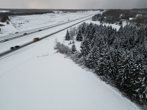 Tallinn-Narva highway on a winter day and spruce forest. Photo from a drone. High quality photo