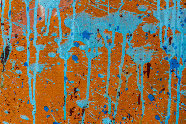White plastered wall splattered with red paint. Paint splashes on the wall. Painted plaster wall. Abstract background. Painted plaster texture.