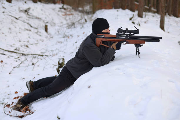 istock a man with a rifle on the snow and aims at a target 1969534963