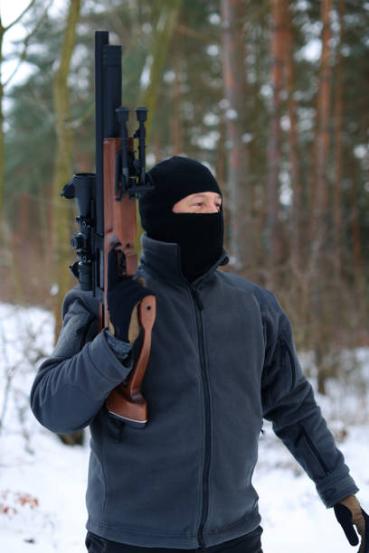 istock A shooting instructor walks through the winter forest with his weapon raised 1969535502