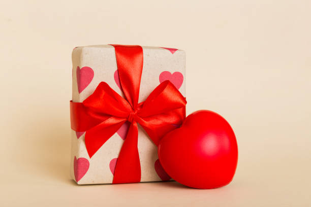 istock gift box with red bow and red heart on colored background. Perspective view. Flat lay 1969540951