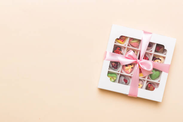 istock Box with sweet chocolate candies on color background, Various candy sweets. Valentines day gift box. Top view flat lay with copy space 1969542626
