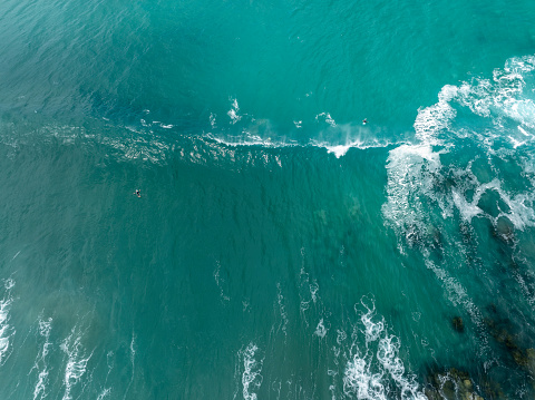 An aerial of surfers paddling in great surf.