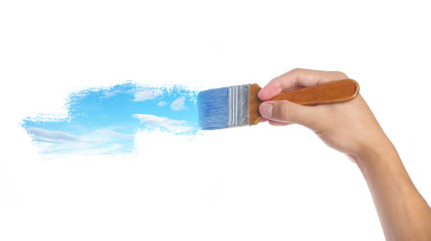 istock Hand with paintbrush painting sky isolated on white background 1969555507