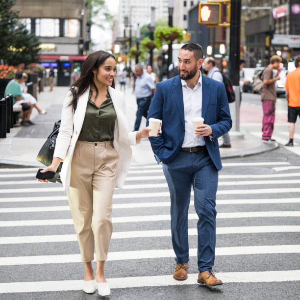 istock Friendly office colleagues crossing street with coffee 1969565515