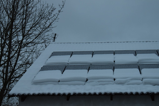 Solar panels partly covered in snow - low efficiency.