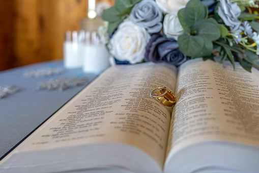 A pair of wedding bands on the open pages of the Bible