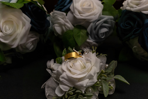 A Close-up of wedding rings lying delicately atop a beautiful bridal bouquet during the Gaddy wedding in Hurricane, WV