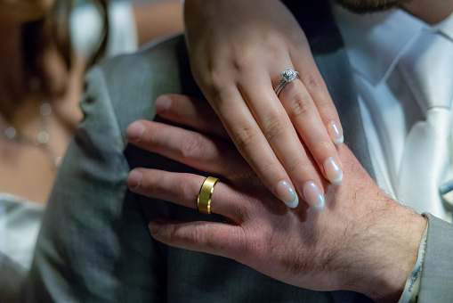 A touching moment as newlyweds, their wedding rings a symbol of their love and commitment