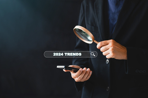 Businessman Hand with magnifier search for 2024 TRENDS analysis SEO Search Engine Optimization Marketing Ranking Traffic Website Internet Business Technology Concept.