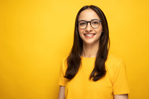 Portrait of lovely positive girl wear eyeglasses empty space isolated on yellow color background