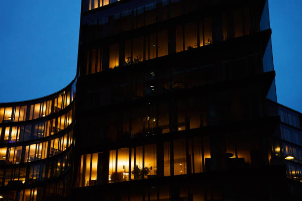 istock Office building exterior with glowing lights in windows at night city 1969621076