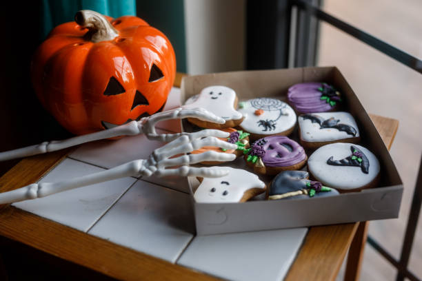 Skeleton hands reaching for Halloween themed cookies