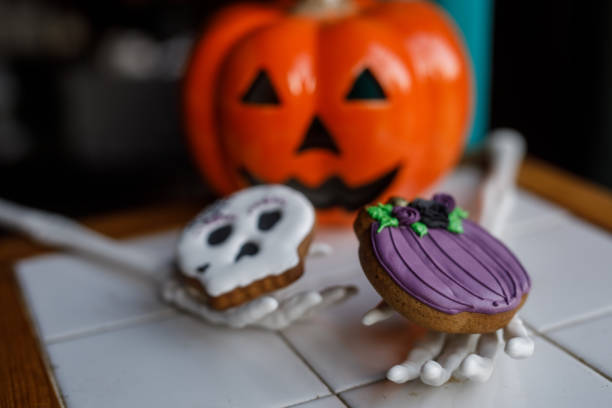 Fake skeleton hands holding Halloween themed cookies