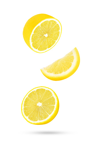 Slices of fresh lemon falling in the air isolated on white background