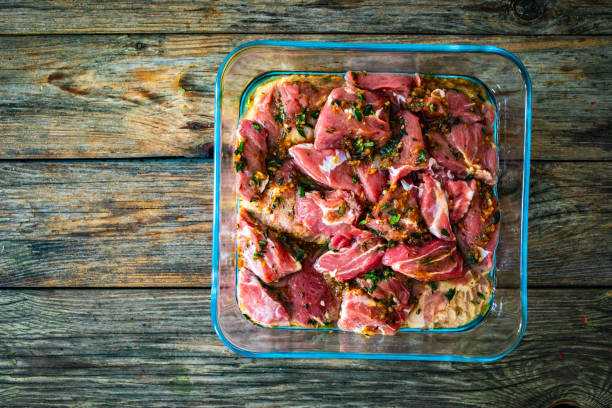 istock Raw pickled pork cheeks in heat-resistant dish on wooden table 1969646594