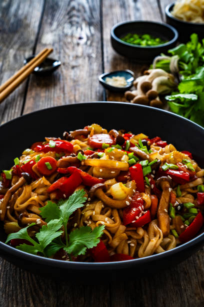 istock Asian style stir fried vegetables and noodles on wooden table 1969661993