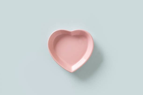 istock Valentines Day concept with empty pink plate heart shaped isolated on blue background. 1969699811