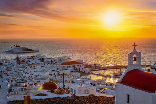 Beautiful sunset view of the town of Mykonos island, Cyclades, Greece, with a traditional church in front