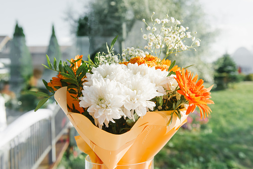 A festive bouquet with white chrysanthemums and orange gerberas for a birthday or wedding
