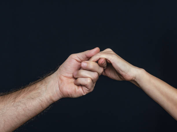 istock A man hand holds woman hand gently on black background 1969771246
