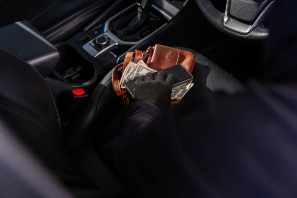 istock A thief is in the act of stealing valuables from a car 1969771817