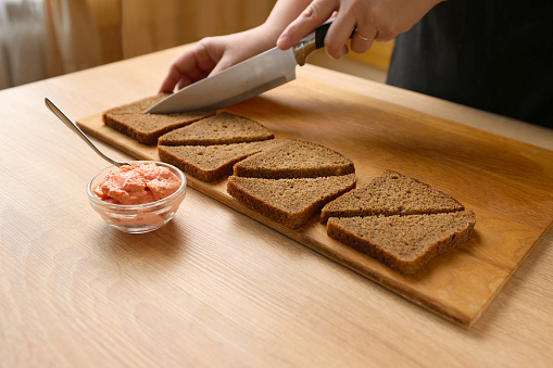 To prepare canapes with fish pate, black bread is cut into pieces