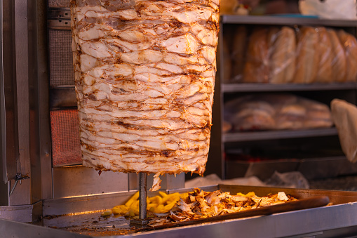 Close-up of grilled meat on a vertical grill is used in traditional street food doner kebab or shawarma