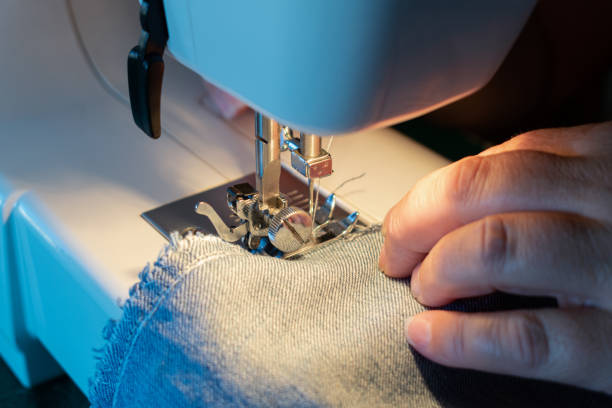 Close-up of a woman's hands sewing a pants using the sewing machine