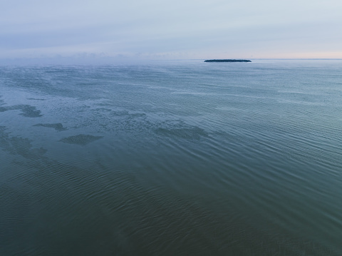 Estonia, Baltic Sea in winter, wind from the shore, view of a small island. Air photography. High quality photo