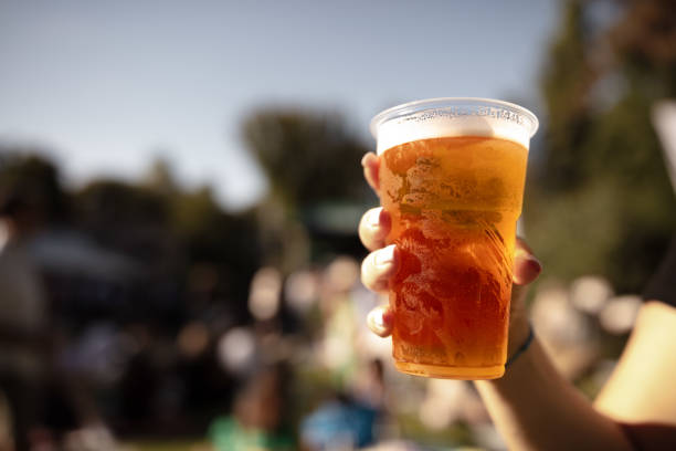 istock Person holding beer cup outdoors on a sunny day. 1969809514