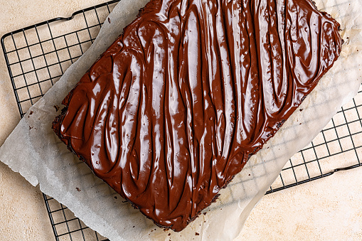 Chocolate moist buttermilk sheet cake with chocolate butter cream, homemade dessert on a cookig resting tray.