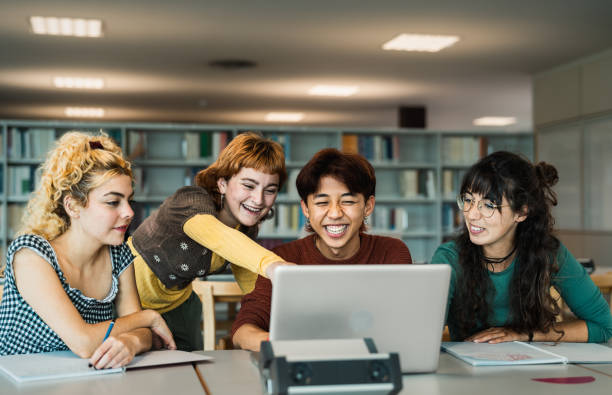 istock Young university students using laptop and studying with books in library - School education concep 1969828206