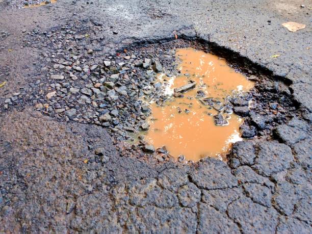 istock The asphalt road is damaged and has holes 1969845458