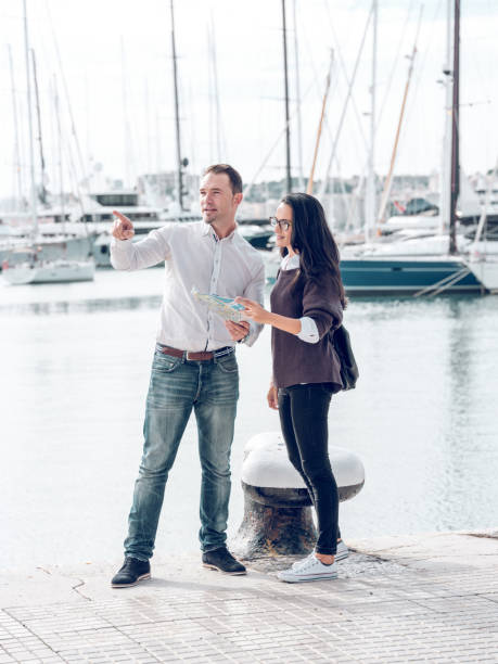 Man explaining route to woman on quay