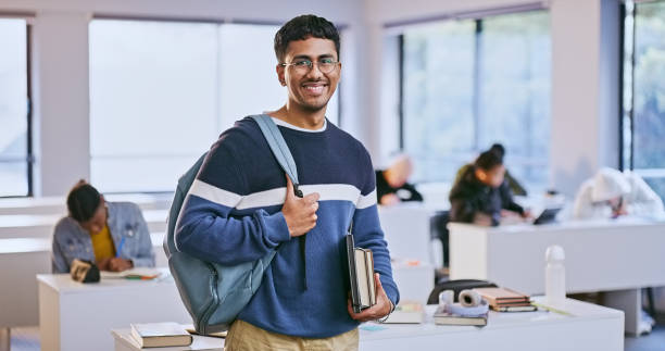 istock Happy, student and portrait of man in class at university with backpack and books for learning. Smile, confident and young male person from Mexico at college campus with scholarship studying for test 1969855078